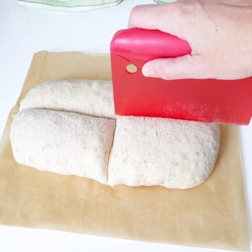 raw bread dough on parchment paper gets shaped by hand - BREADISTA