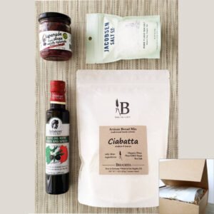 Birdsview of Mediterranean Bread Salt Giftbox content - with Artisan bread mix, black olive tapenade in jar, olive oil bottle, flaky salt pouch in magnetic lid box