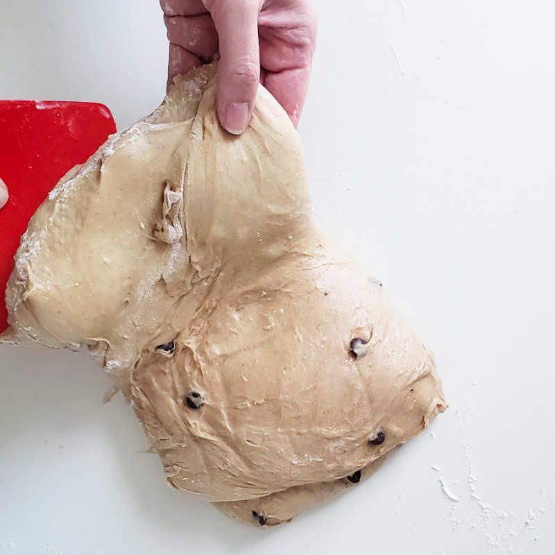 Birdview - one hand hold folded sticky Colomba dough at the edge ready for another fold