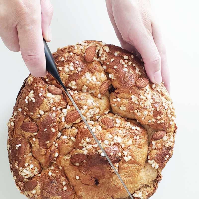 Homemade Italian Easter Bread - hold with one hand and knife in other hand ready to be sliced - birdview