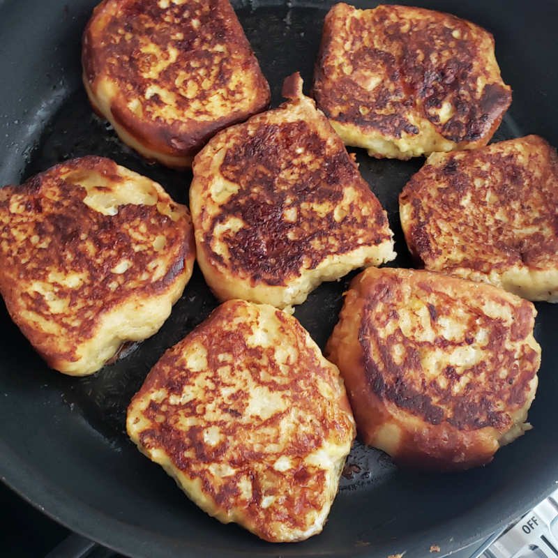 birdview - 7 frying slices of french toast in pan with browned side up by BREADISTA
