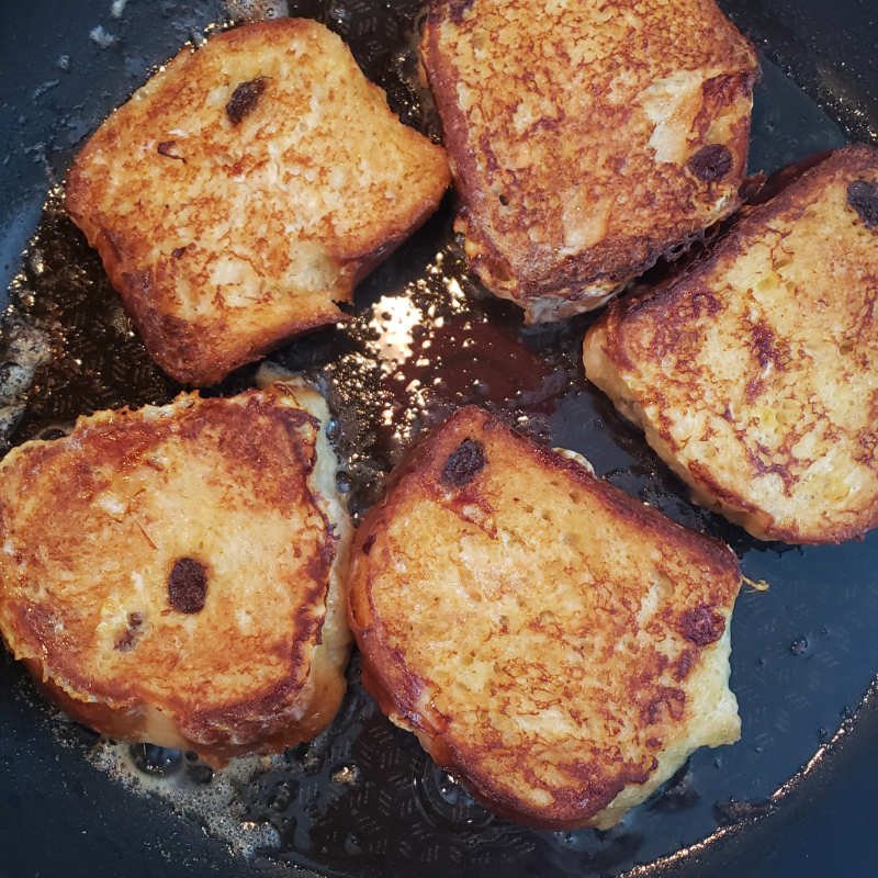 birdview - 5 frying slices of french toast in butter with browned side up by BREADISTA