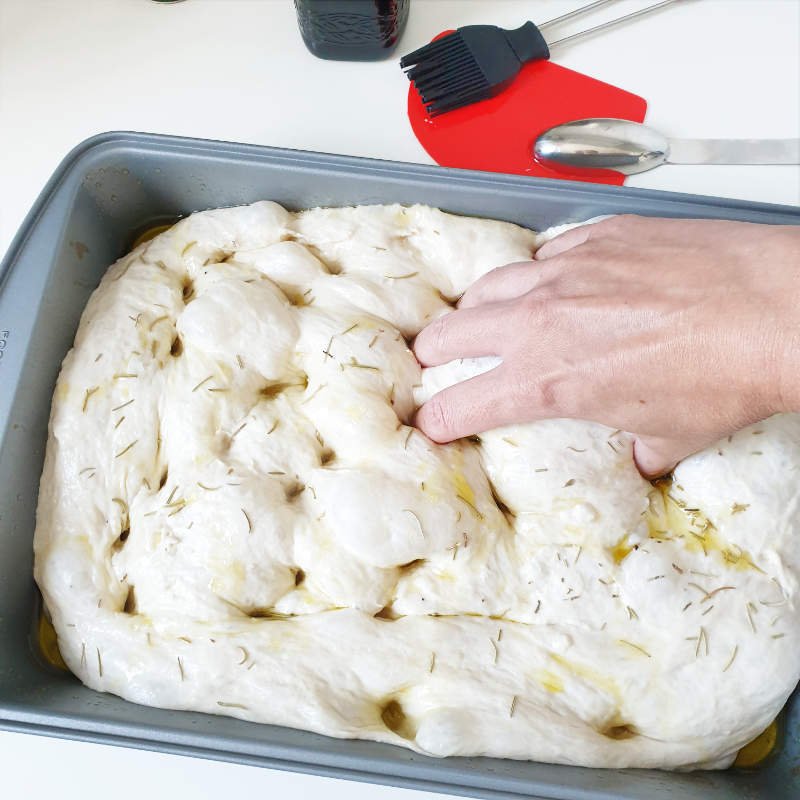 Shape Foccacia - risen dough in pan gets dimpled with fingers by BREADISTA