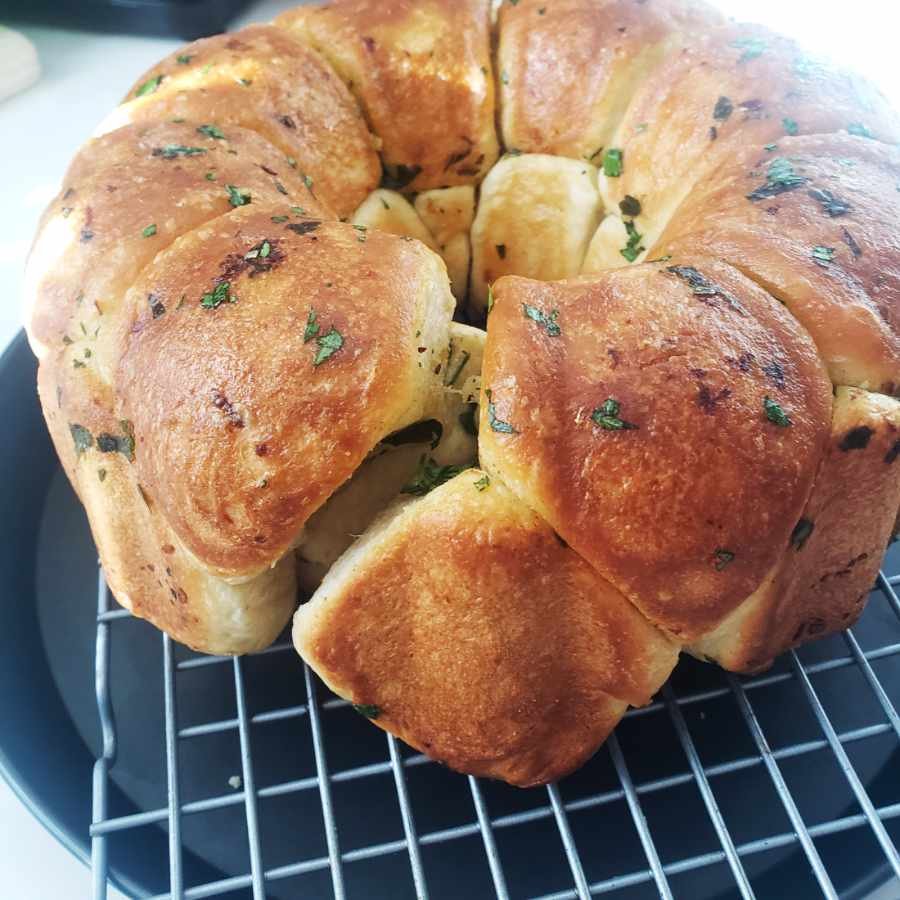 Baked Monkey Bread upside down brushed with garlic oil  on cooling rack - Recipe by BREADISTA