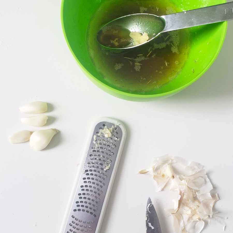 ingredients half way processed for garlic oil with green bowl and grater