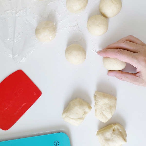 birdview - hand shapes small raw dough pieces into round balls - BREADISTA