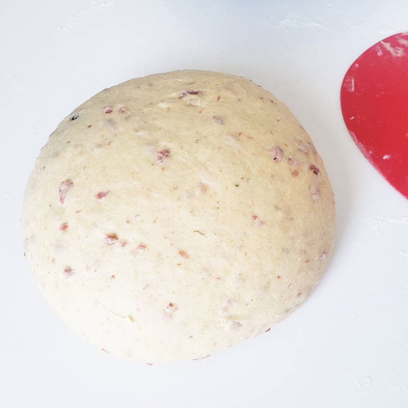 close up - raw shaped dough ball with bits of bacon in it