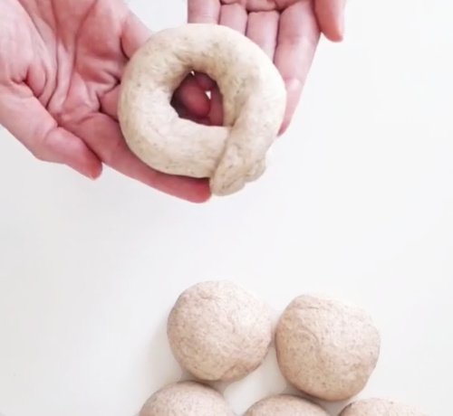 Bagel Shaping Version 'Eyelet' - one raw shaped bagel on two hands- BREADISTA