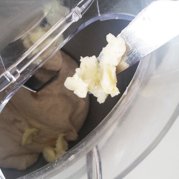 Dough in Machine w/ butter on knife - closeup