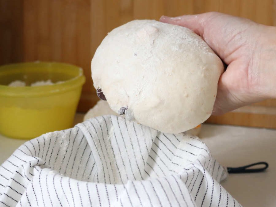 raw shaped dough piece ready to proof in a towel lined cereal bowl - Breadista