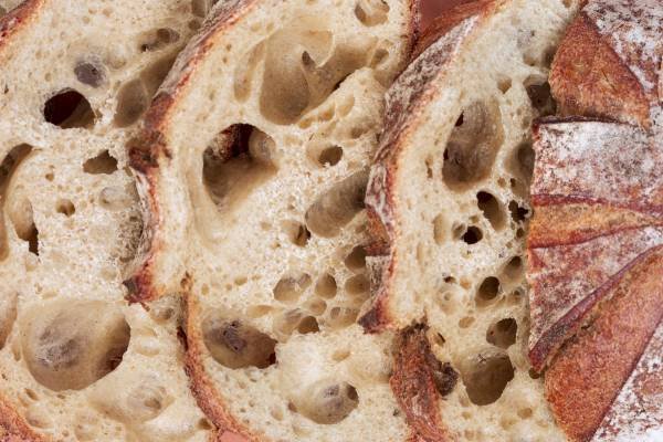 overlapping slices of classic Sourdough Loaf - closeup, showing many wholes