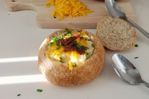 Soup served in bread bowl topped with cheese and bacon bites - by BREADISTA and Chew on This - 2026