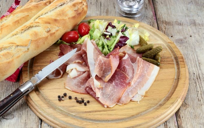 Ritual: German Abendbrot. Shows: Vesperbrett with ham, pickles, bread on wooden board - by BREADISTA